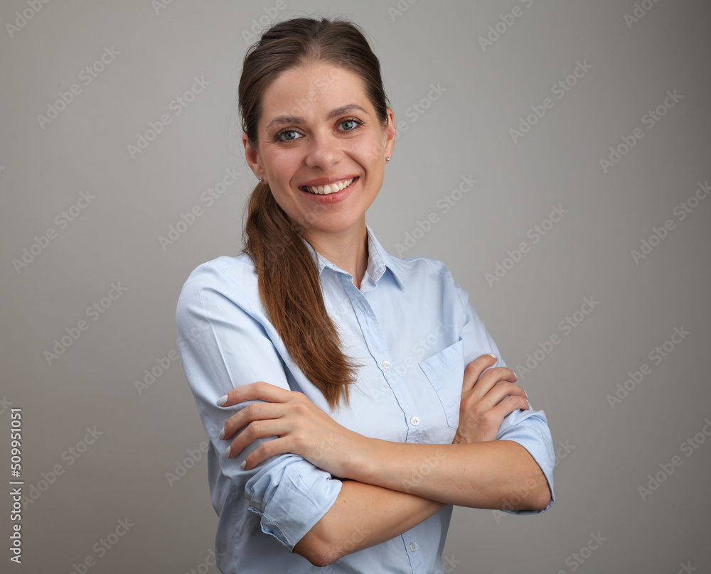 Smiling young woman with long hair wearing blue shirt standing with crossed arms. Smiling young woman with long hair wearing blue shirt standing with crossed arms.