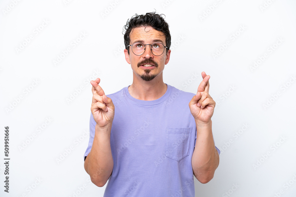 Young man with moustache isolated on white background with fingers crossing and wishing the best Young man with moustache isolated on white background with fingers crossing and wishing the best