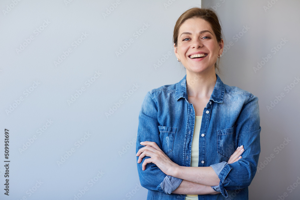 Isolated woman smiling and standing with crossed arms in casual blue shirt. Isolated woman smiling and standing with crossed arms in casual blue shirt.