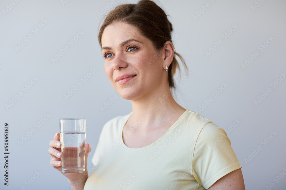 Smiling woman drinking water looking away. Girl in casual clothes isolated portrait. Smiling woman drinking water looking away. Girl in casual clothes isolated portrait.