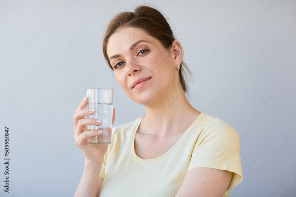 Smiling woman drinking water with glass, isolated head shot. Smiling woman drinking water with glass, isolated head shot.
