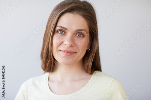 Smiling woman close up face portrait. Girl looking away. Female head shot with shallow depth of field.
