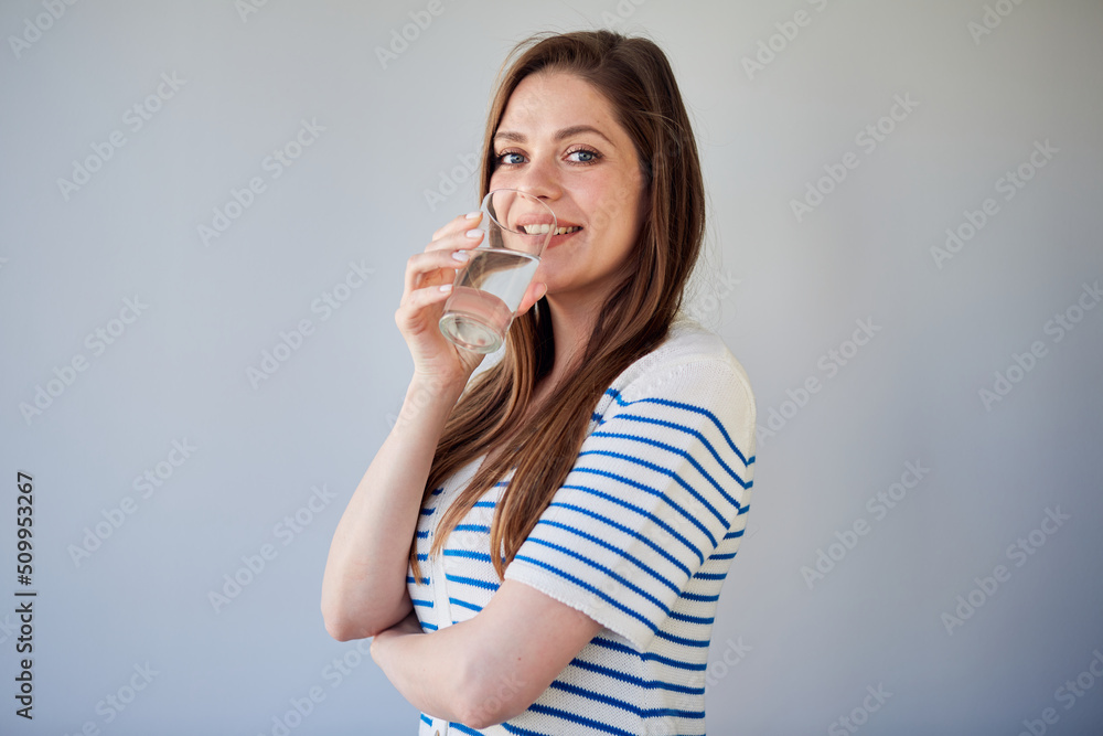 Woman in casual dress drinking water. isolated portrait of smiling girl. Woman in casual dress drinking water. isolated portrait of smiling girl.