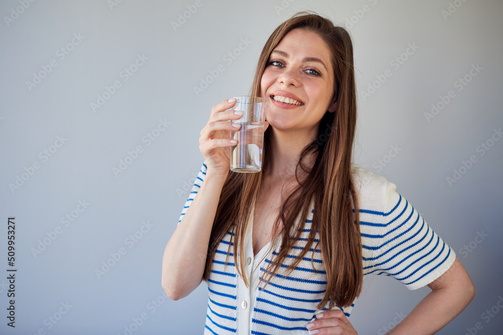 Woman in casual dress drinking water. isolated portrait of smiling girl. Woman in casual dress drinking water. isolated portrait of smiling girl.