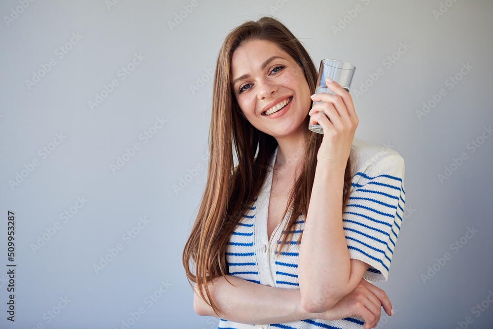 Happy woman holding water glass. isolated portrait of girl with long hair wearing in striped white dress. Happy woman holding water glass. isolated portrait of girl with long hair wearing in striped white dress.