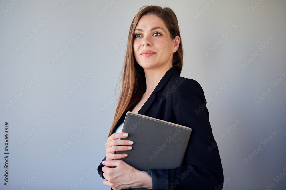 Woman in black business suit holding book and looking away. isolated portrait of business woman with long hair. Woman in black business suit holding book and looking away. isolated portrait of business woman with long hair.