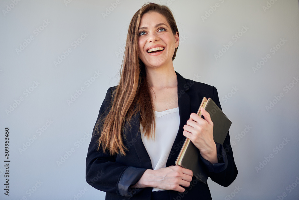 Smiling woman teacher or girl student in black suit holding book looking away. Smiling woman teacher or girl student in black suit holding book looking away.