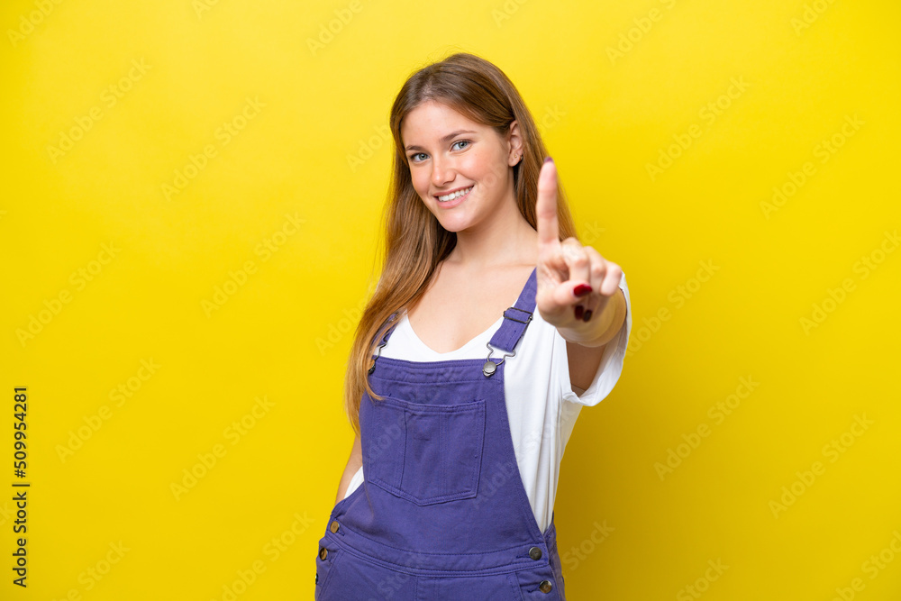 Young caucasian woman isolated on yellow background showing and lifting a finger