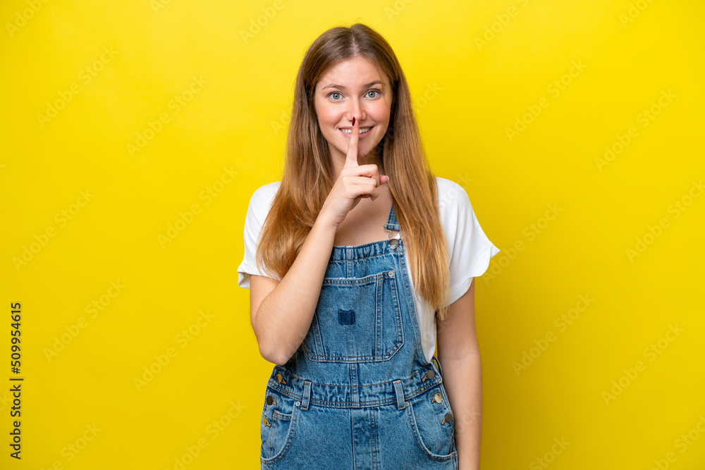 Young caucasian woman isolated on yellow background showing a sign of silence gesture putting finger in mouth Young caucasian woman isolated on yellow background showing a sign of silence gesture putting finger in mouth