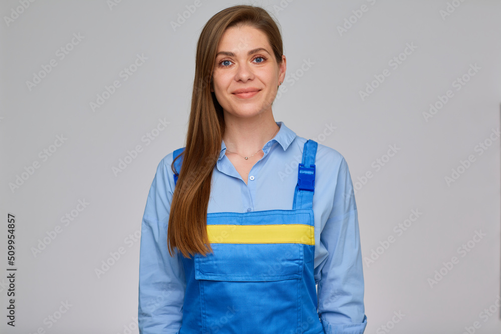 Smiling woman builder, plumber or elictrician in blue overalls with yellow stripe. isolated portrait of happy student girl with long hair. Smiling woman builder, plumber or elictrician in blue overalls with yellow stripe. isolated portrait of happy student girl with long hair.