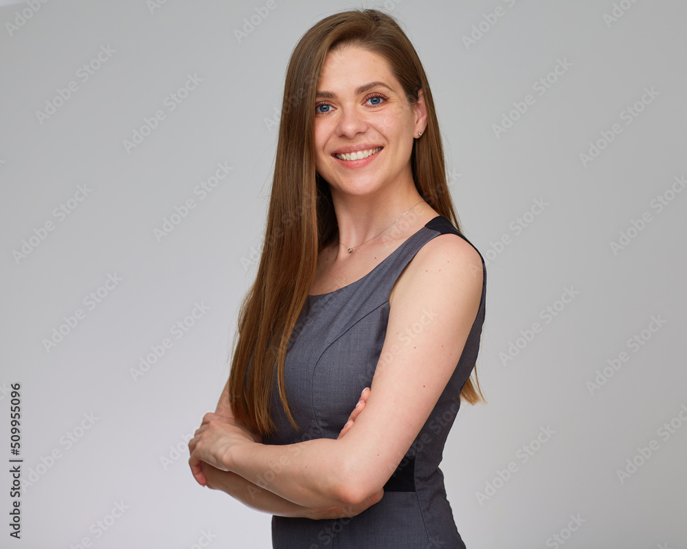 Smiling business woman wearing dress standing with crossed arms. isolated studio portrait on gray. Smiling business woman wearing dress standing with crossed arms. isolated studio portrait on gray.