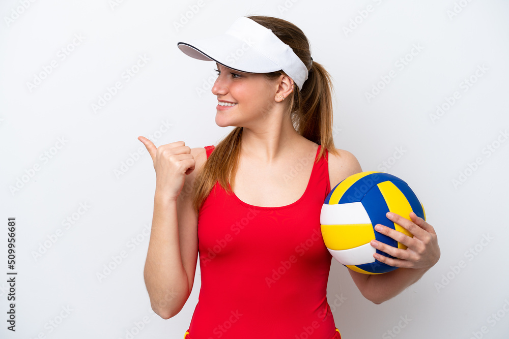 Young caucasian woman playing volleyball isolated on white background pointing to the side to present a product