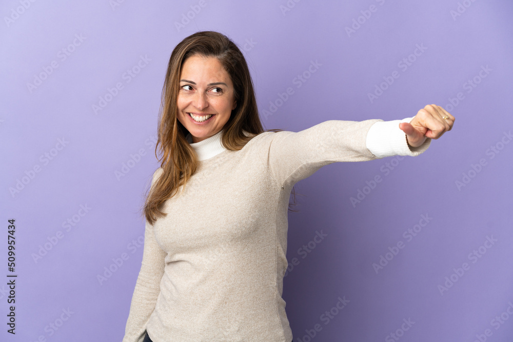 Middle age Brazilian woman isolated on purple background giving a thumbs up gesture Middle age Brazilian woman isolated on purple background giving a thumbs up gesture