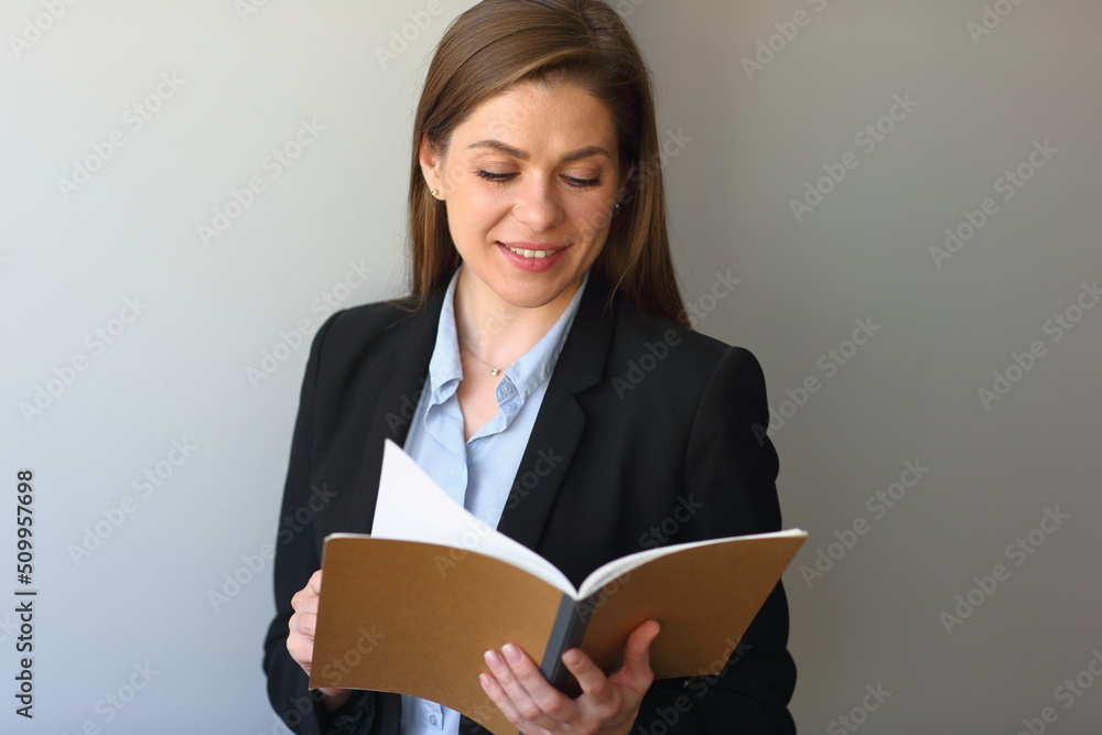 Teacher woman or girl student wearing black suit read open book and smile. Teacher woman or girl student wearing black suit read open book and smile.