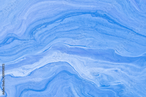 Abstract fluid art background light blue colors. Liquid marble. Acrylic painting on canvas with denim gradient.