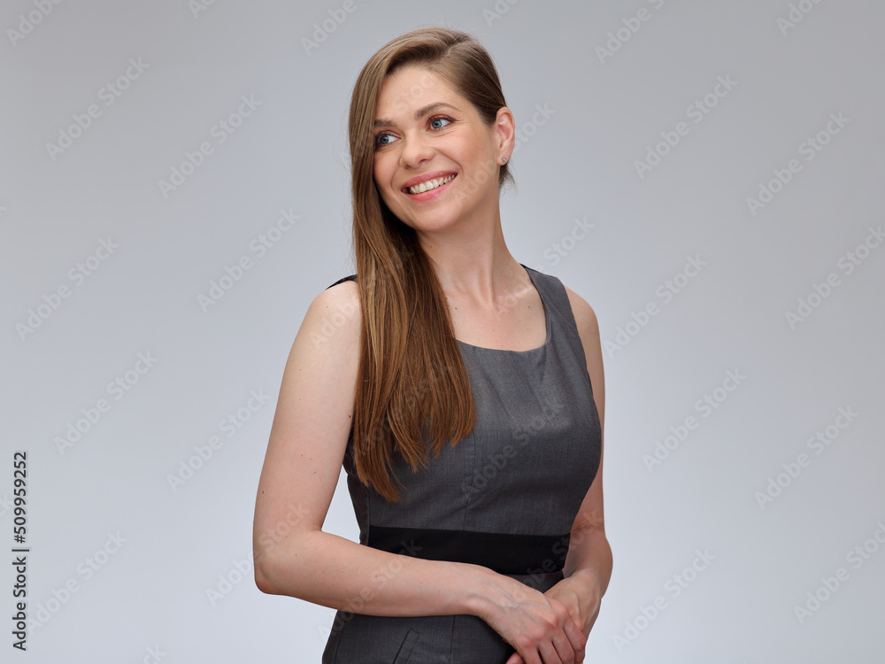 Smiling woman in business dress standing with folded hands looking back over shoulder. woman isolated portrait. Smiling woman in business dress standing with folded hands looking back over shoulder. woman isolated portrait.
