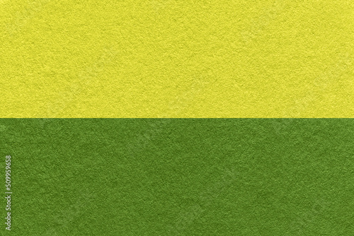 Texture of craft dark green and yellow paper background, half two colors, macro. Structure of vintage olive cardboard.