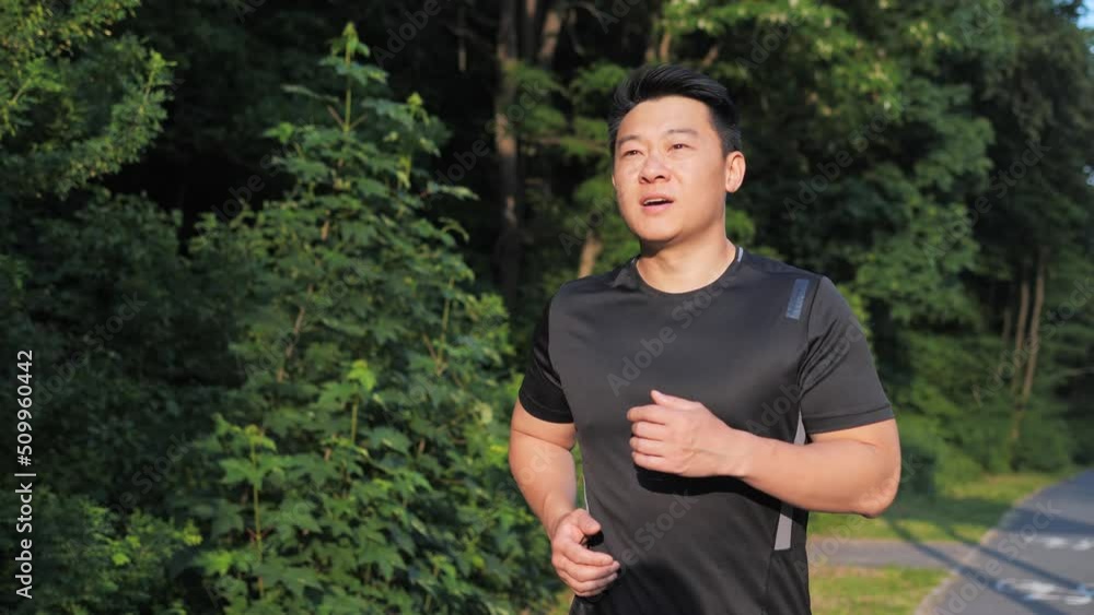 Japanese Sportsman Jog Cardio Workout. Runner Fitness Hard Training Before Running Marathon Competition. Running Man Fitness Exercising. Athlete Jogging In Park Preparing Triathlon Sunset Time. Japanese Sportsman Jog Cardio Workout. Runner Fitness Hard Training Before Running Marathon Competition. Running Man Fitness Exercising. Athlete Jogging In Park Preparing Triathlon Sunset Time.