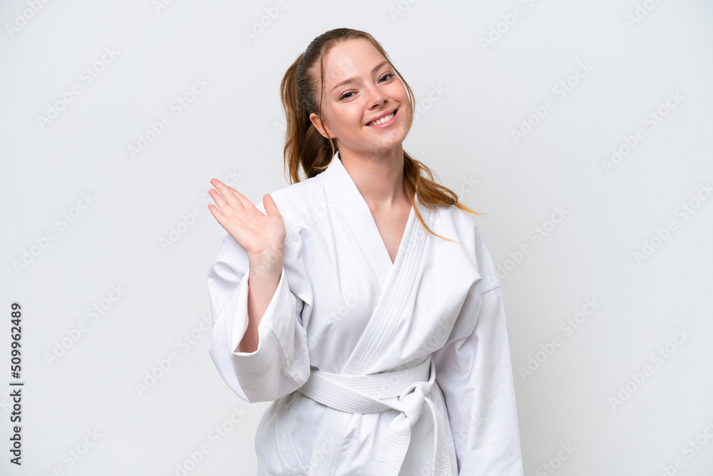 Young caucasian girl doing karate isolated on white background saluting with hand with happy expression Young caucasian girl doing karate isolated on white background saluting with hand with happy expression