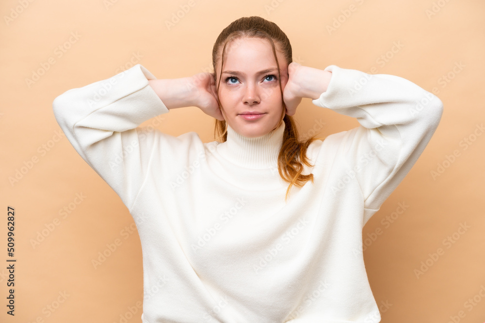 Young caucasian woman isolated on beige background frustrated and covering ears Young caucasian woman isolated on beige background frustrated and covering ears