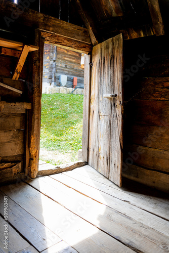 Opened door of an old wooden cottage