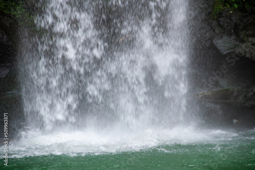 Blue flowing water under the waterfall