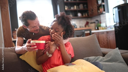 Young couple celebrating at home.Man giving gift to his girlfriend.