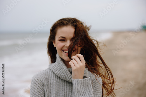 beautiful woman red hair in a sweater by the ocean Relaxation concept