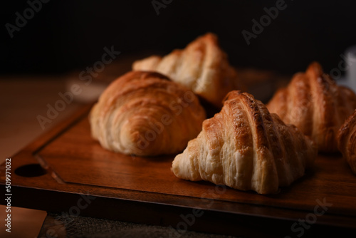 Buttery croissants on wooden board for breakfast. Levitation, bread bakery products cafe concept
