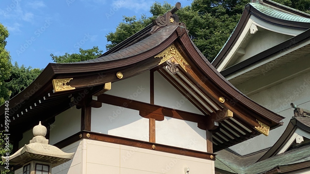 The rooftop gold emblem decor of ancient Japanese shrine house, Ueno park Gojyoten Jinjya” temple, year 2022 sunny weekday The rooftop gold emblem decor of ancient Japanese shrine house, Ueno park Gojyoten Jinjya” temple, year 2022 sunny weekday