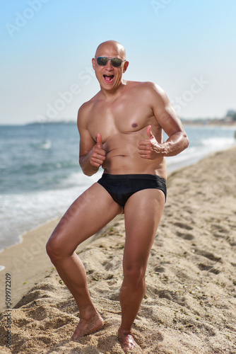 bald man on the beach by the sea on vacation