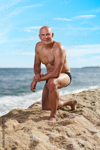 bald man on the beach by the sea on vacation