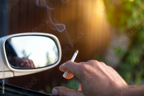 the danger of smoking cigarettes in a car on the background of a rearview mirror, the front and back background is blurred with a bokeh effect