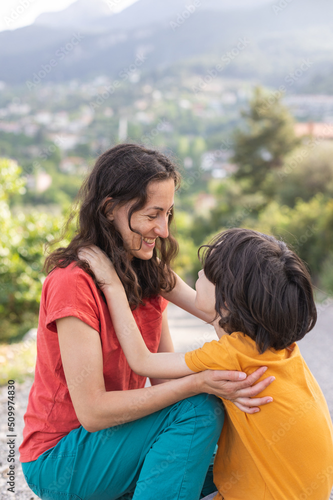Fototapeta premium A boy hugs his mother, a woman spends time with a child in nature