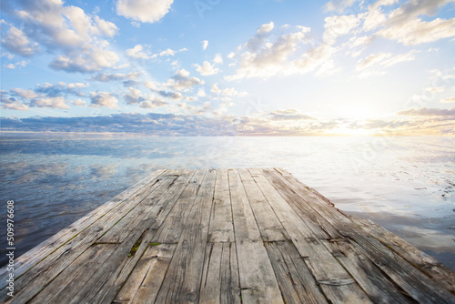 Obraz na plátně Empty wooden jetty at sunset, looking out over water