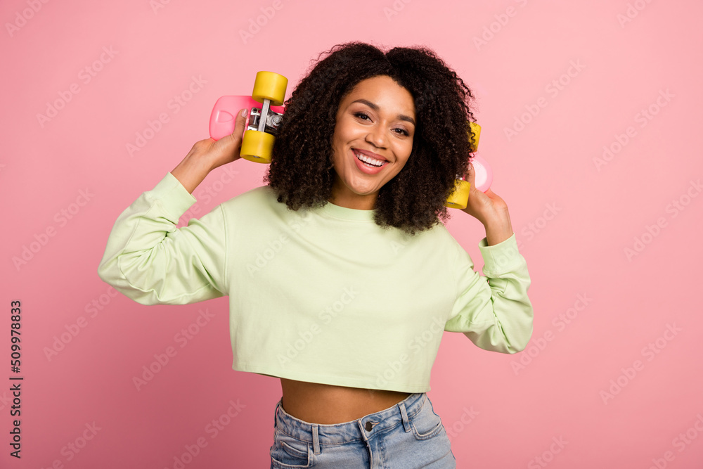 Photo of young cheerful lovely lady hold skateboard sportive weekend isolated over pink color background Photo of young cheerful lovely lady hold skateboard sportive weekend isolated over pink color background
