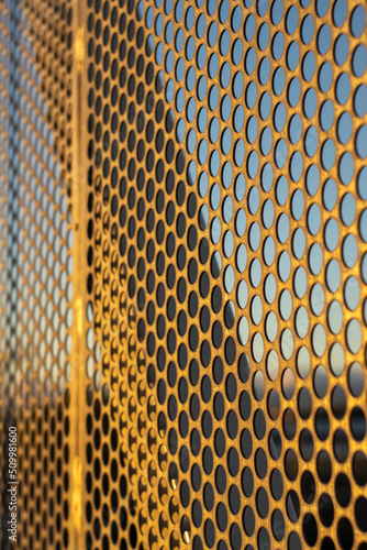 aluminum composite panels or cladding with perforated sheets on modern building facade on sunset, Abstract architecture background concept.