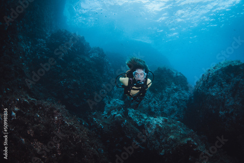 Young woman doing Scuba-diving in the crystal water of the Mediterranean Sea