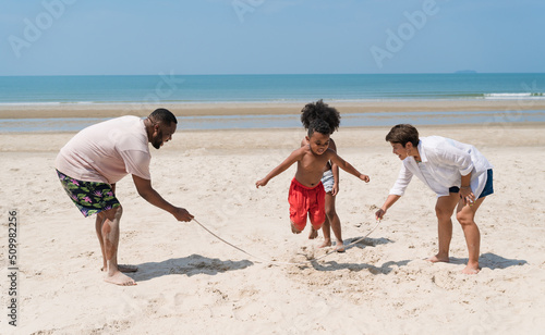 Happy African American family play jumping rope on the beach © chachamp