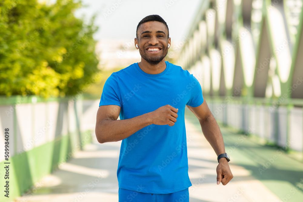 Portrait of an athletic young man running outdoors on a bridge Portrait of an athletic young man running outdoors on a bridge