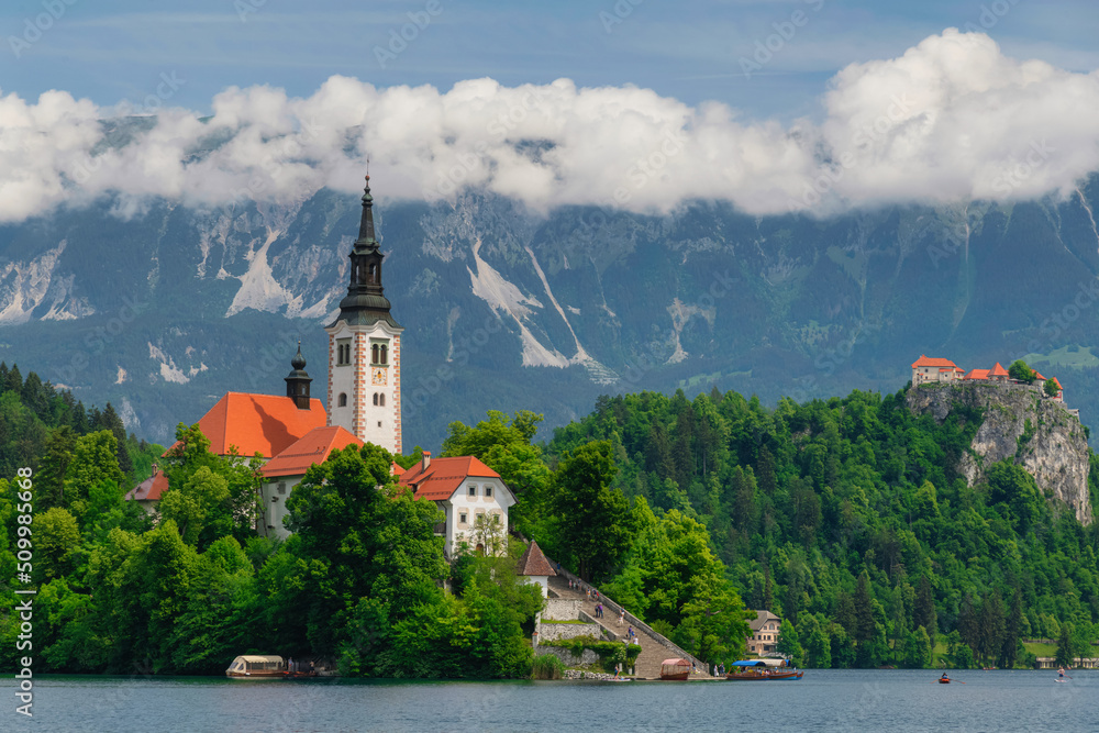Beautiful Lake Bled in Slovenia. 'Church dedicated to the Assumption of Mary' - Santa Maria Church with surrounding houses and clock tower in the middle of small islet in the famous slovenian lake. 
