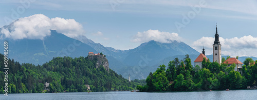 Beautiful Lake Bled in Slovenia. 'Church dedicated to the Assumption of Mary' - Santa Maria Church with surrounding houses and clock tower in the middle of small islet in the famous slovenian lake.  photo
