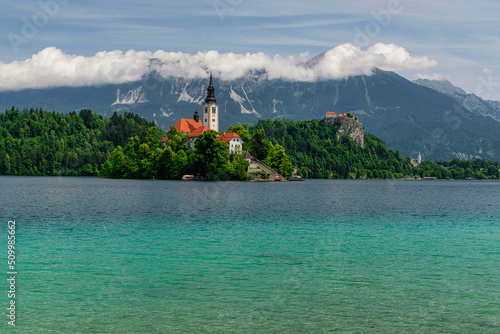 Beautiful Lake Bled in Slovenia. 'Church dedicated to the Assumption of Mary' - Santa Maria Church with surrounding houses and clock tower in the middle of small islet in the famous slovenian lake.  photo
