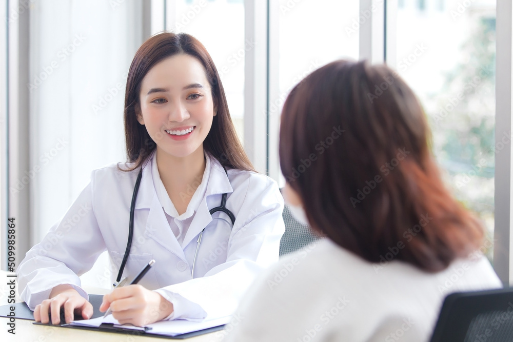 Asian professional doctor woman who wears medical coat talks with woman patient to suggest treatment guideline and healthcare concept in office of hospital. Asian professional doctor woman who wears medical coat talks with woman patient to suggest treatment guideline and healthcare concept in office of hospital.