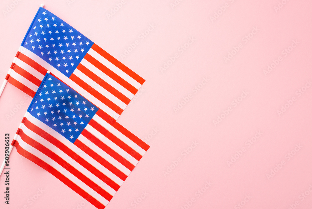Fototapeta premium USA Independence Day concept. Top view photo of two national flags on isolated pastel pink background with copyspace