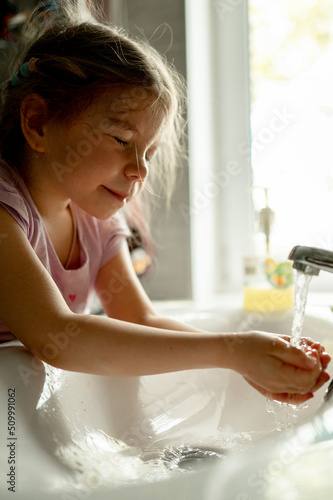 A little girl brushes her teeth at home in the morning. The child washes  observes hygiene