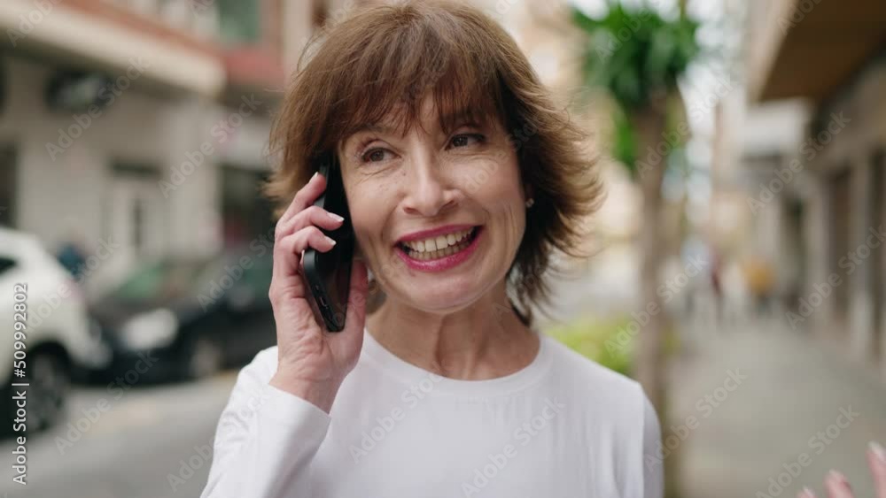 Middle age woman smiling confident talking on the smartphone at street Middle age woman smiling confident talking on the smartphone at street