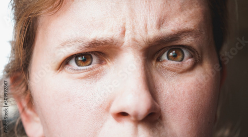 close up of a woman face with a distrust expression in her face