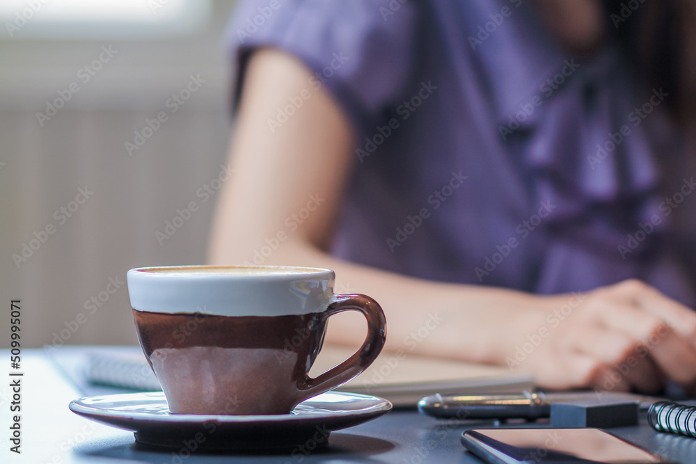 Ceramic coffee cups filled with hot coffee are placed on a table in a coffee shop after a businesswoman orders hot coffee to relax during her lunch break. Copy space is available for inserting text Ceramic coffee cups filled with hot coffee are placed on a table in a coffee shop after a businesswoman orders hot coffee to relax during her lunch break. Copy space is available for inserting text