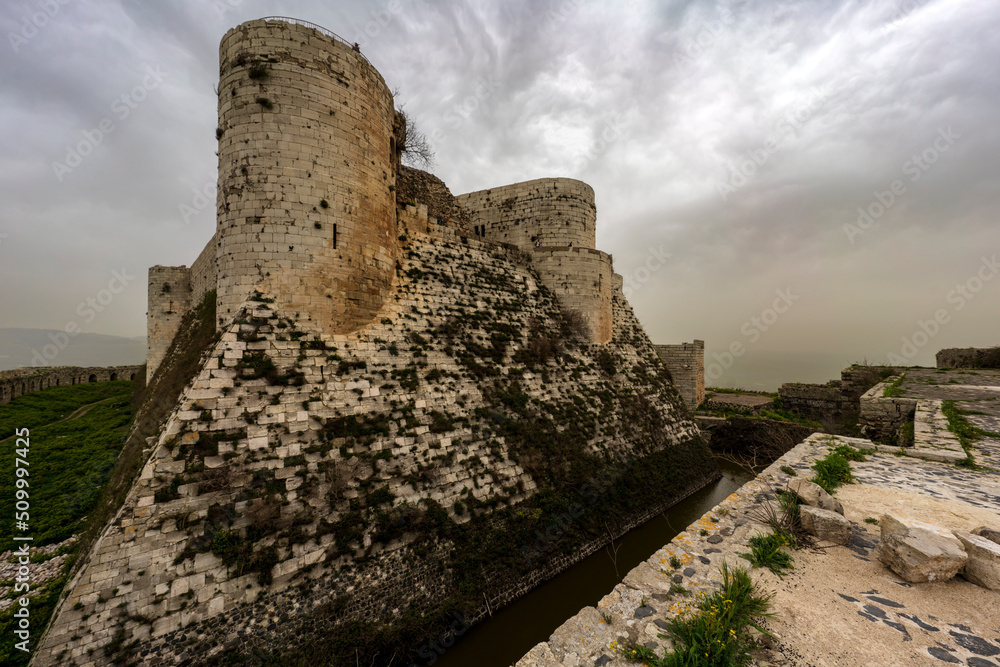 Krak des Chevaliers medieval crusader castle in Syria, a world heritage site. - obrazy, fototapety, plakaty 